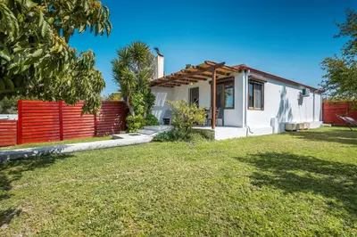 a small white house with a red fence at Ily’s House in Pastida