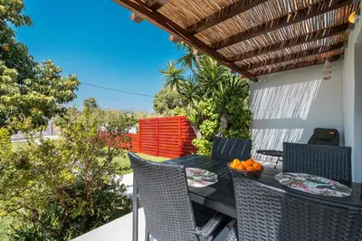 a patio with a table and chairs on a balcony at Ily’s House in Pastida