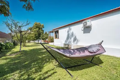 a hammock in a yard next to a house at Ily’s House in Pastida