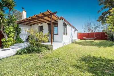 a small white house with a grass yard at Ily’s House in Pastida