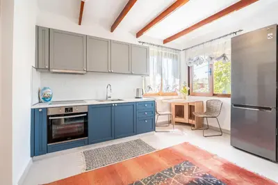 a kitchen with blue cabinets and a table with chairs at Ily’s House in Pastida
