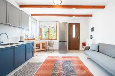 a kitchen and living room with blue cabinets and a couch at Ily’s House in Pastida