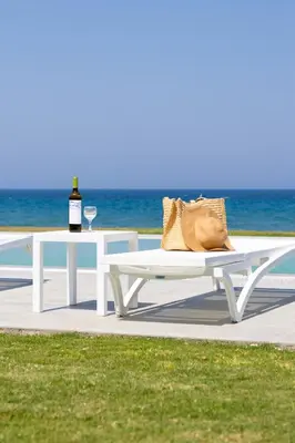 a white picnic table with a bottle of wine and a glass at Liam Beach Front Luxury Villa with 100m2 infinity pool in Phanaes