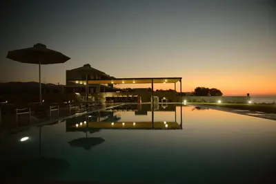 a swimming pool with an umbrella and a building at Liam Beach Front Luxury Villa with 100m2 infinity pool in Phanaes