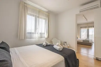 a white bedroom with a bed with two towels on it at RLM Prime Beach Panoramic Villa in Kolimbia