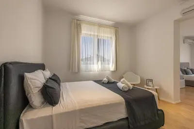 a bedroom with a bed with two pillows and a window at RLM Prime Beach Panoramic Villa in Kolimbia