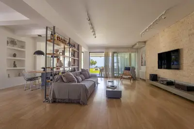 a living room with a couch and a tv in it at RLM Prime Beach Panoramic Villa in Kolimbia