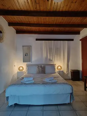 a bedroom with a large bed with two lights on it at Spot on the sea in Archangelos