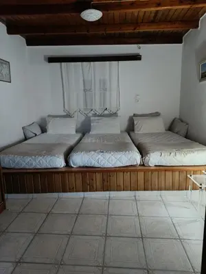 two beds in a room with a window at Spot on the sea in Archangelos