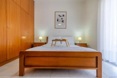 a bed with a wooden frame in a bedroom at Mike's House in Kremasti near the Beach Rhodes in Kremasti