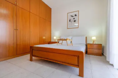 a bedroom with a bed and wooden cabinets at Mike's House in Kremasti near the Beach Rhodes in Kremasti