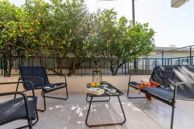 a patio with chairs and a table and orange trees at Mike's House in Kremasti near the Beach Rhodes in Kremasti