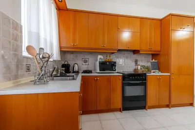 a kitchen with wooden cabinets and a sink and a stove at Mike's House in Kremasti near the Beach Rhodes in Kremasti