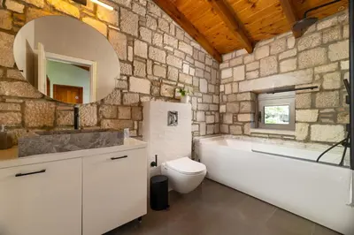 a bathroom with a tub and a toilet and a mirror at Villa Roi in Kalathos