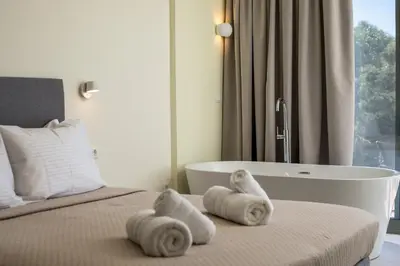 a bedroom with a bed and a bath tub at Eden's Azalea Luxury Suite in Rhodes Town