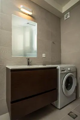 a bathroom with a washing machine and a sink at Eden's Azalea Luxury Suite in Rhodes Town