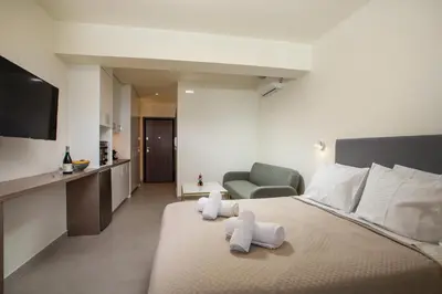 a hotel room with a bed with towels on it at Eden's Azalea Luxury Suite in Rhodes Town