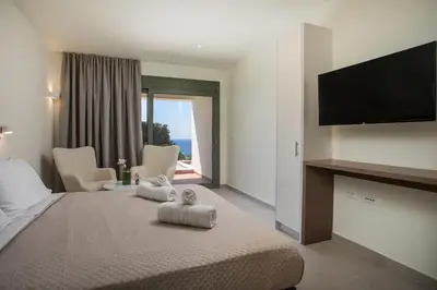 a hotel room with a bed with a flat screen tv at Eden's Azalea Luxury Suite in Rhodes Town