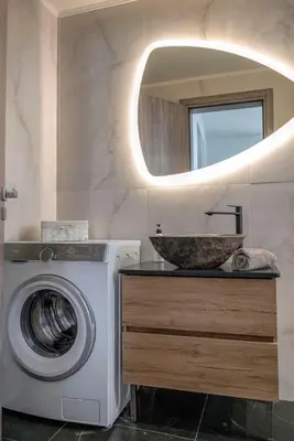 a bathroom with a washing machine and a sink at Calliope's Rhodes City Comfort in Rhodes Town