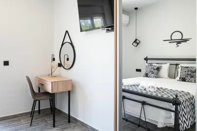 a bedroom with a bed and a desk and a mirror at Calliope's Rhodes City Comfort in Rhodes Town