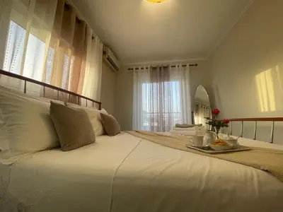 a large white bed with a tray of food on it at Summer Diamond in Kremasti