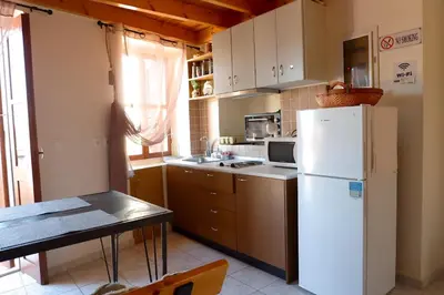 a kitchen with a white refrigerator and a table at Aeneo Studio 2 in Symi