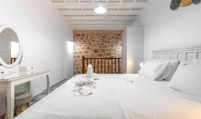a bedroom with a large white bed and a sink at Villa del Capo Suites in Rhodes Town