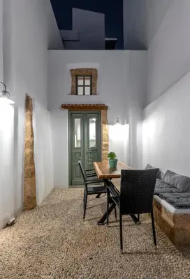 a dining room with a table and chairs and a couch at Villa del Capo Suites in Rhodes Town