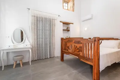 a bedroom with a bed and a desk and a mirror at Villa del Capo Suites in Rhodes Town