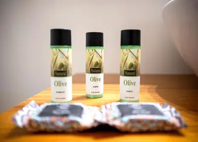 three bottles of olive oil on a wooden table at Villa del Capo Suites in Rhodes Town