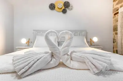 two towels in the shape of swans on a bed at Villa del Capo Suites in Rhodes Town