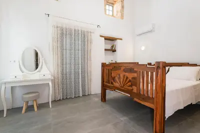 a bedroom with a bed and a desk and a mirror at Villa del Capo Suites in Rhodes Town