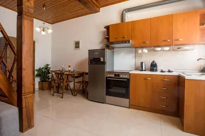 a kitchen with stainless steel appliances and a table at Rhodes VistaPeak Retreat in Áyios Isídhoros