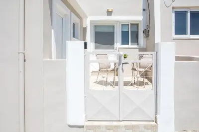 a white door leading to a patio with chairs at Rhodes VistaPeak Retreat in Áyios Isídhoros