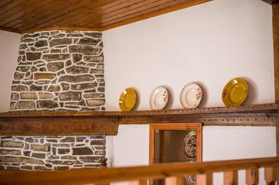 a row of plates on a shelf next to a stone wall at Rhodes VistaPeak Retreat in Áyios Isídhoros