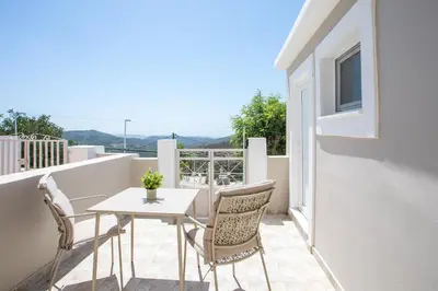 a table and chairs on a balcony with a view at Rhodes VistaPeak Retreat in Áyios Isídhoros