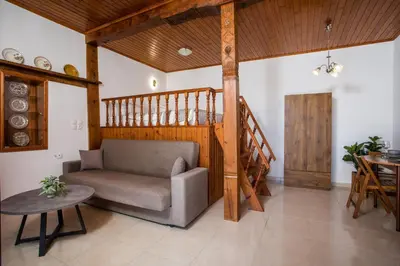 a living room with a chair and a wooden staircase at Rhodes VistaPeak Retreat in Áyios Isídhoros