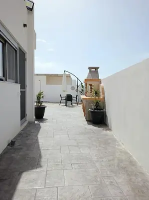 a patio with potted plants on the side of a building at Traounou Bay villa in Afantou