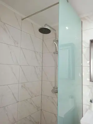 a shower with a glass door in a bathroom at Traounou Bay villa in Afantou