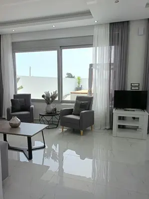 a living room with a television and a couch and chairs at Traounou Bay villa in Afantou