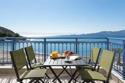 a table and chairs on a balcony with a view of the ocean at Artoria Apartment 1 Groundfloor in Haraki
