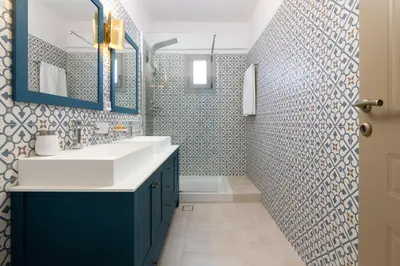 a bathroom with blue and white tiled walls at Artoria Apartment 1 Groundfloor in Haraki