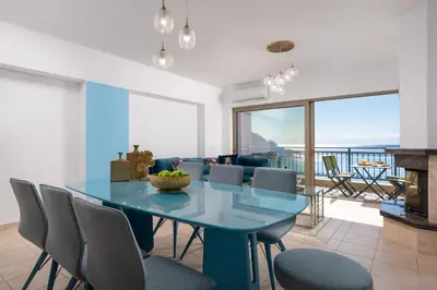 a dining room with a blue table and chairs at Artoria Apartment 1 Groundfloor in Haraki