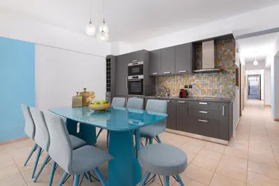 a kitchen with a blue table and chairs at Artoria Apartment 1 Groundfloor in Haraki
