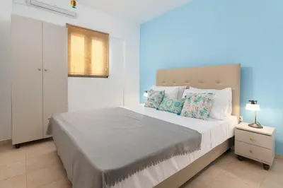 a bedroom with a large white bed with pillows at Artoria Apartment 1 Groundfloor in Haraki