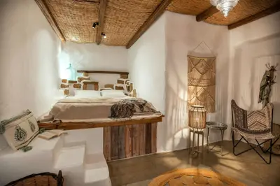 a bedroom with a bed and a chair at Ninémia Sea living in Archangelos