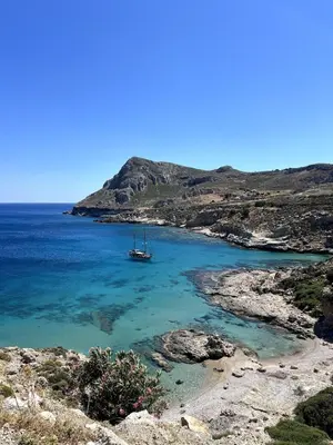 a boat in the water next to a beach at Ninémia Sea living in Archangelos