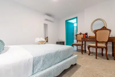 a bedroom with a bed and a desk and chairs at Casa Ifestou in Rhodes Town