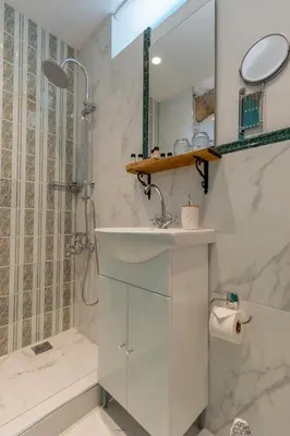 a white bathroom with a sink and a shower at Casa Ifestou in Rhodes Town
