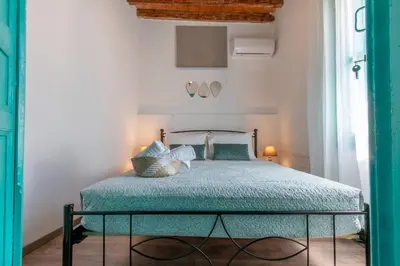 a bedroom with a bed with a green comforter at Casa Ifestou in Rhodes Town